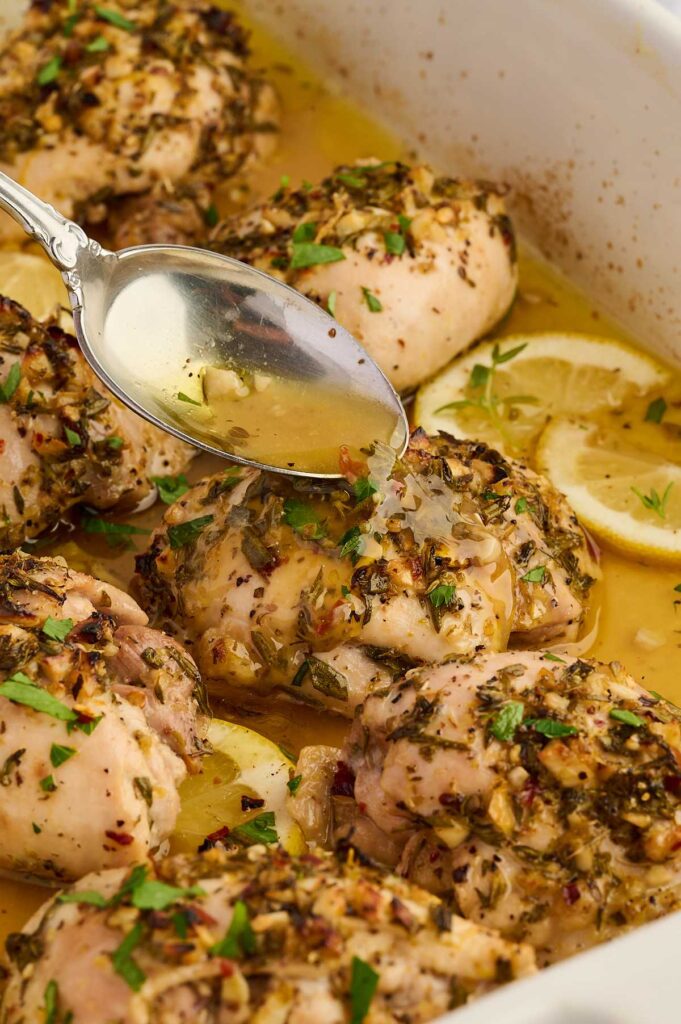 Chicken thighs coated in Greek lemon marinade before baking.