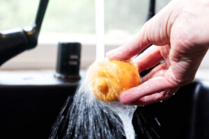 Rinsing a preserved lemon under running water.