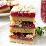 Finished raspberry crumble bars with buttery shortbread crust and raspberry jam filling.