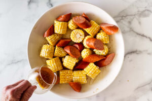 Sheet pan shrimp boil with tail-on shrimp and browned smoked sausage.