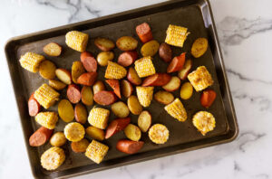 Seasoned shrimp ready to broil with potatoes, corn, and sausage.