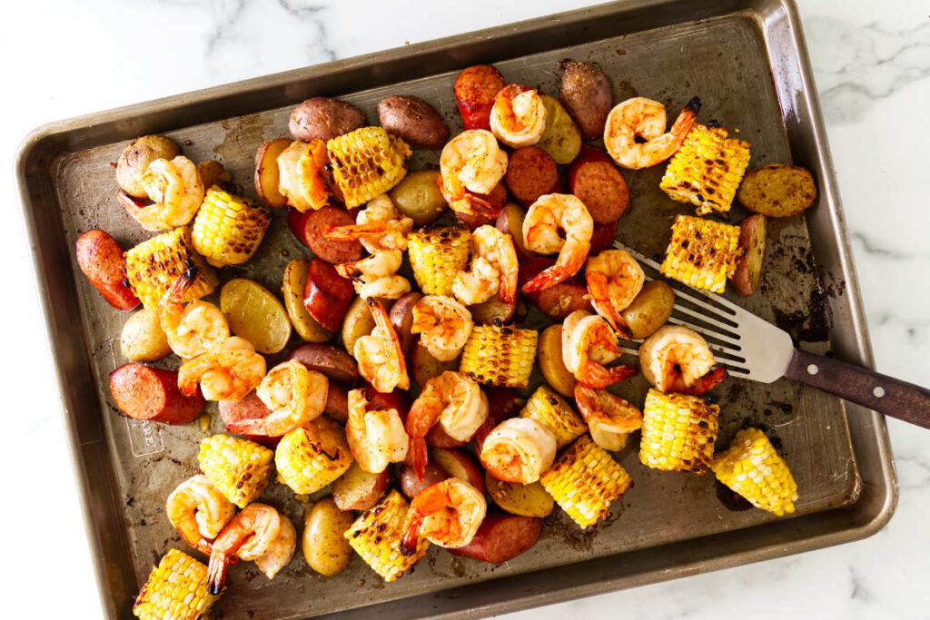 Large shrimp broiled with Old Bay seasoning for a sheet pan shrimp boil.