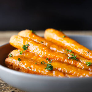 Smoked carrots in a ceramic dish sprinkled with parsley.
