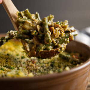 A spoon scooping green bean casserole from a dish.