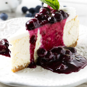 Homemade blueberry sauce recipe on a slice of cheesecake.