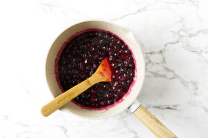 Fresh blueberry sauce cooking in a saucepan.
