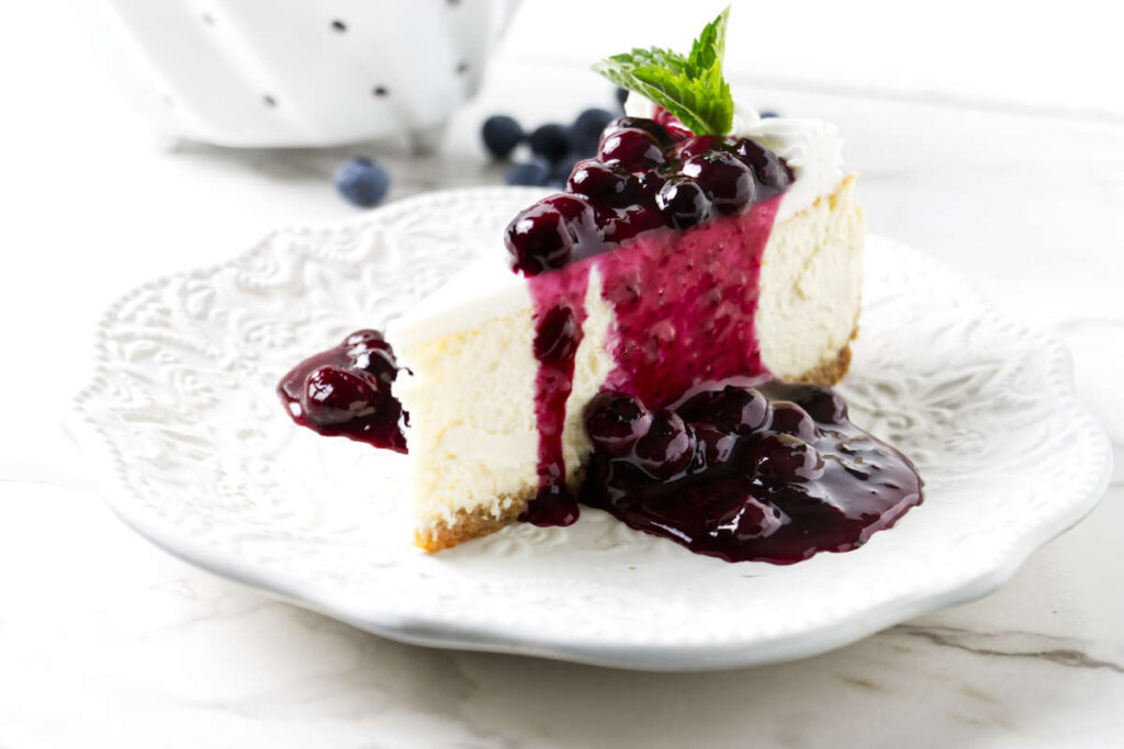 Blueberry sauce over a slice of cheesecake.