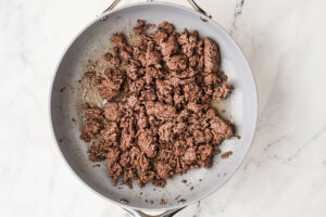 Browned ground beef crumbles in a skillet for taco meat.