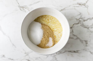 Mixing graham cracker crust in a bowl for blueberry cheesecake bars.