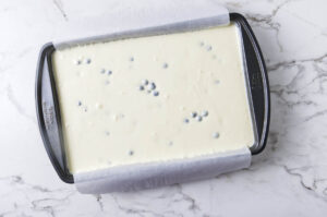 Blueberry cheesecake filling poured into a baking pan.