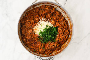 Ground beef zucchini boat filling with Parmesan cheese and herbs stirred in.