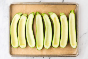 Zucchini shells arranged on a sheet pan for stuffed zucchini boats.