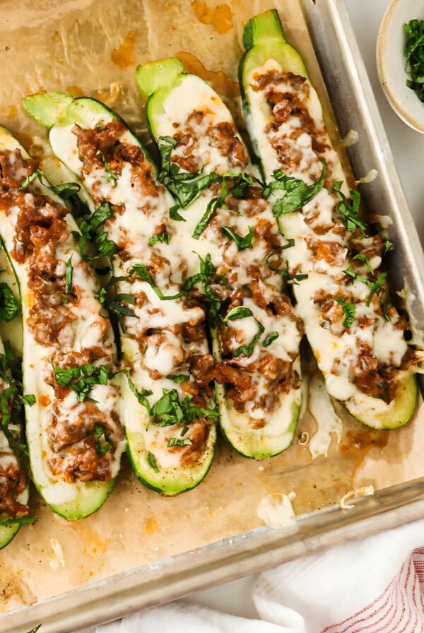 Italian stuffed zucchini boats garnished with chopped fresh herbs.