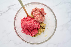 Ground beef and Italian sausage being combined with the breadcrumb mixture for soup meatballs.