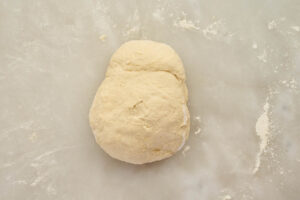 Kneaded dough for garlic knots on a lightly floured work surface.