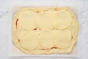 Sliced mozzarella and provolone layered over the stromboli filling.