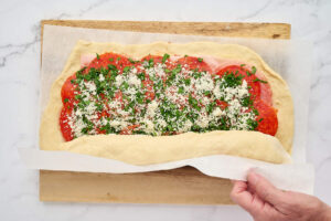 Pizza dough being rolled around the pepperoni stromboli filling.