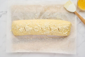 Unbaked meat stromboli brushed with egg wash and cut with vents before baking.
