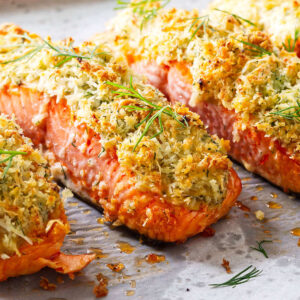 Baked salmon fillets with crispy panko herb crust and fresh dill.