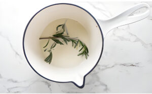 Infusing cream with a sprig of rosemary.