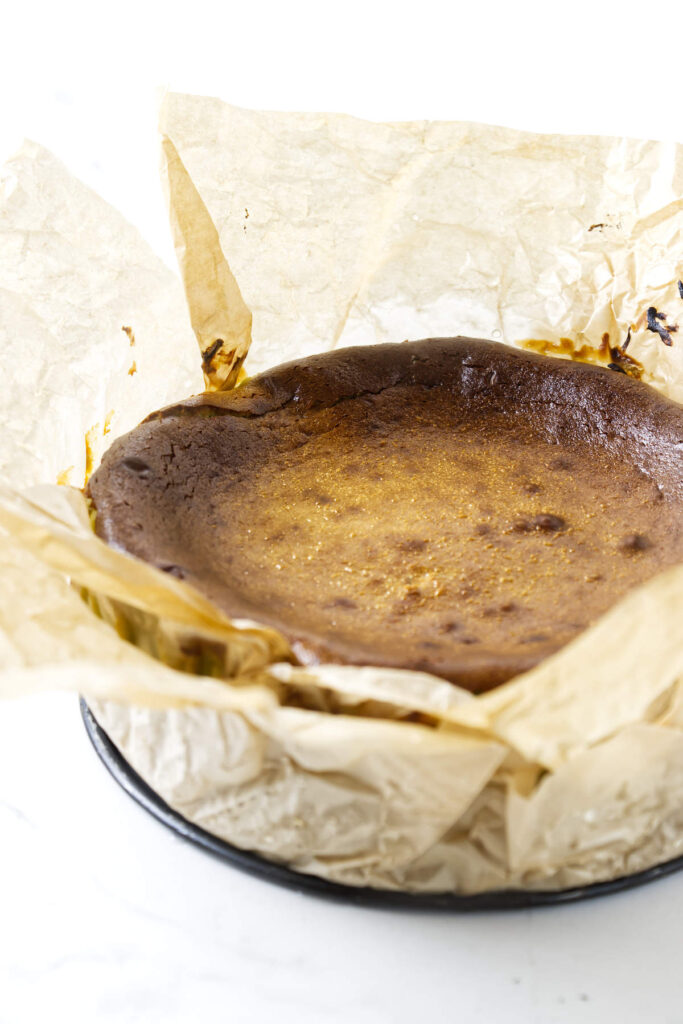 Close-up of the browned top of a freshly baked pistachio Basque cheesecake.
