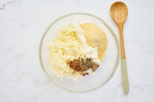 Ricotta cheese, mozzarella, Parmesan, breadcrumbs, and seasonings in a mixing bowl.