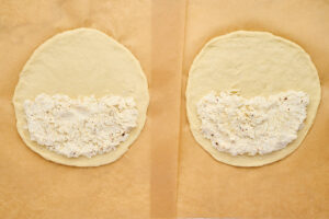Cooked Italian sausage and spinach filling in a skillet for ricotta calzones.