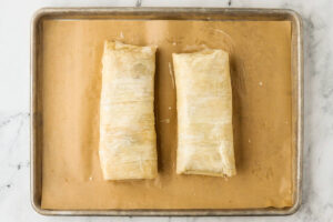 Two rectangular pastry logs on a parchment-lined baking sheet.
