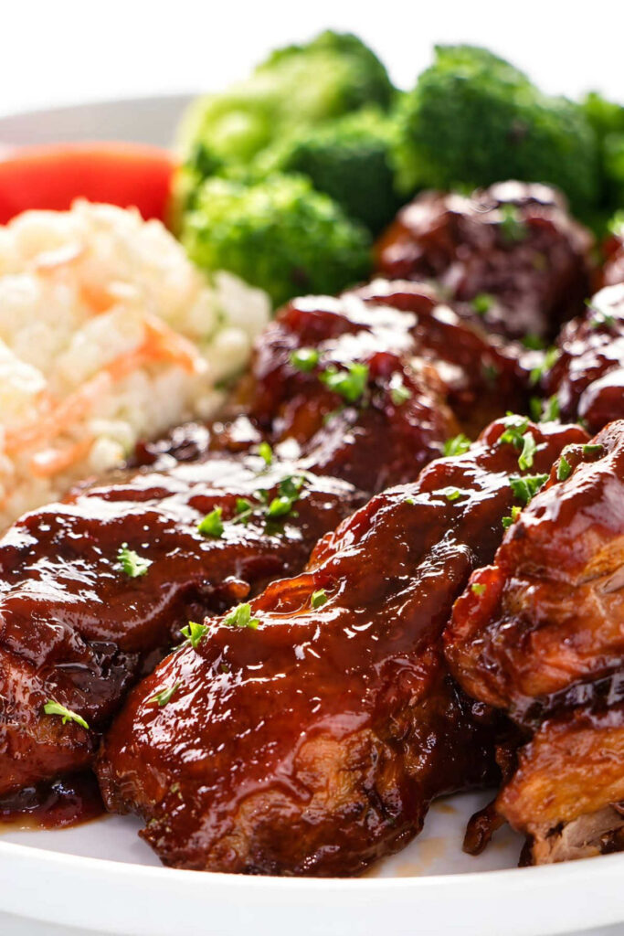country style pork ribs in the oven Barbecue ribs served with coleslaw and broccoli on a plate.