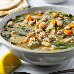Sausage, white bean, and spinach soup served with flatbread.